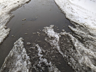 melted dirty snow on city streets photo in the daytime.