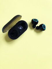 wireless black headphones lie on a yellow background