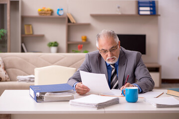 Obraz premium Old male employee working from home during pandemic