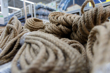 Fototapeta na wymiar Jute rope, rope made of natural material. Many kits nearby, selective focus.