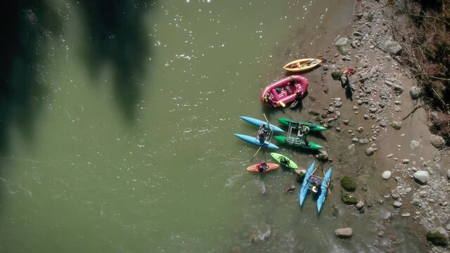 Whitewater River Rafts and Kayaks on Shore with Adventurous Crew Shot by Drone