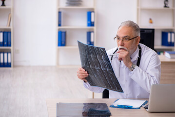 Old male doctor radiologist working in the clinic