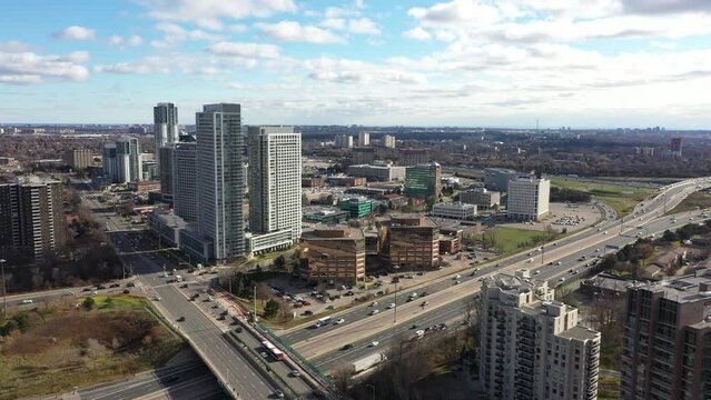 Don Valley Parkway going towards condos with traffic  underneath blue skies and clouds