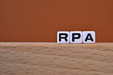 Word cubes lined up with the letters RPA written on it. It is an abbreviation for Robotic Process...