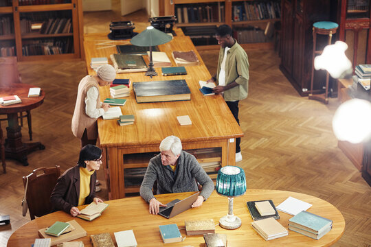 Background image of classic library interior with diverse group of people at wooden table, copy space