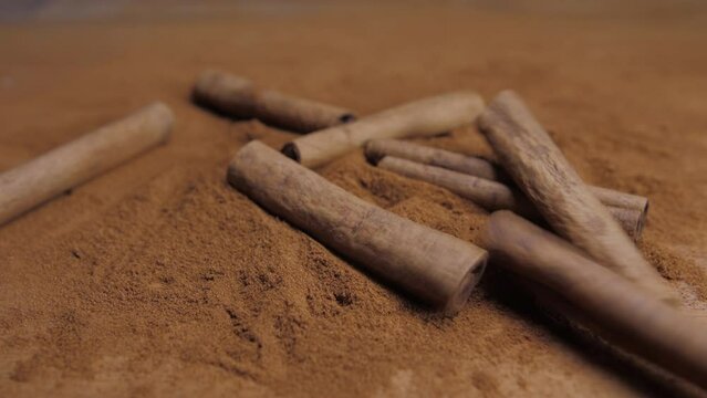 cinnamon sticks falling into powdered cinnamon slow motion 4k