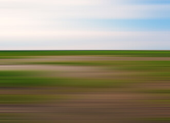 blurred modern minimalist abstract summer country landscape with green and brown land and blue sky