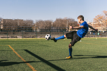 young football player volleys the ball to goal