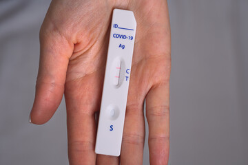 Woman hand holding rapid covid antigen test or express covid test with positive covid-19 result © Creative Cat Studio