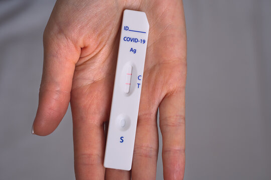 Woman hand holding rapid covid antigen test or express covid test with positive covid-19 result