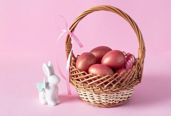 Easter basket with colorful eggs and bunny on pink background. Easter card