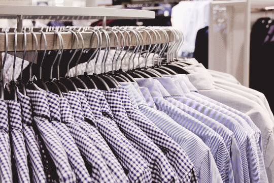 Many men's shirts on hanger in clothing store