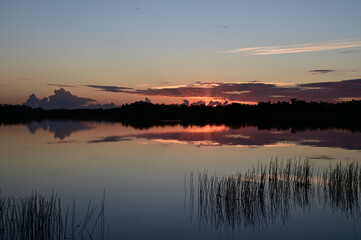 Sunrise cloudscape reflected in tranquil water of Nine Mile Pond in Everglades National Park, Florida.