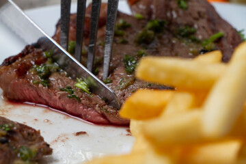 Fork and knife splitting lean beef