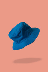 blue bucket hat, coral background 