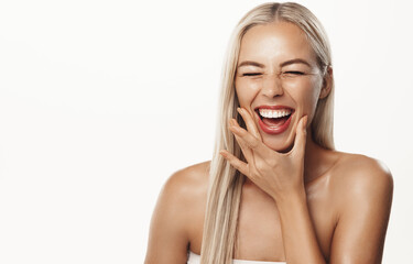 Portrait of blond happy model laughing, showing white healthy teeth, smiling, cleansing skin and...