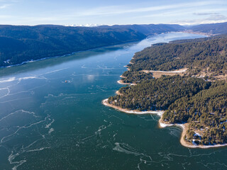 Aerial winter view of Dospat Reservoir covered with ice, Bulgaria