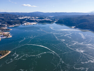 Aerial winter view of Dospat Reservoir covered with ice, Bulgaria