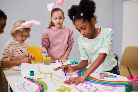 Diverse group of kids at art and craft table on easter party for children