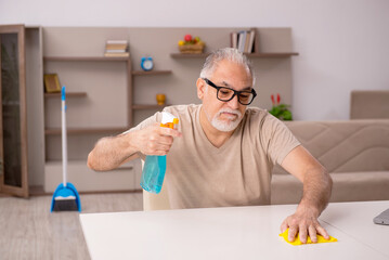 Old man doing housework at home