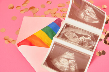 rainbow colors flag and pregnancy ultrasound scan in pink envelope, pregnancy and lgbt couple, pride concept