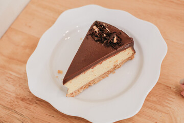 Homemade chocolate cake in white plate on wooden table. Selective focus. Copy space for your text.