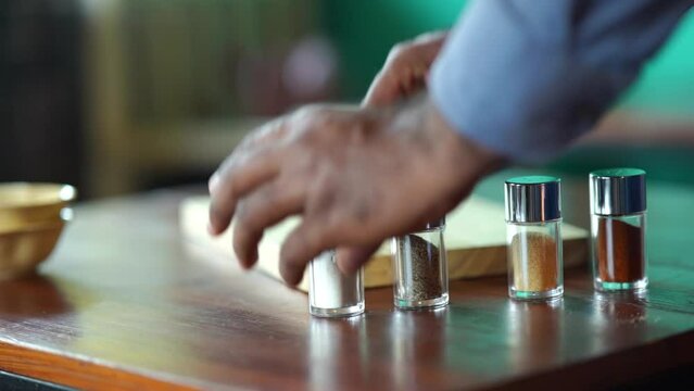 Condiments Shakers Being Placed On Table For Presentation Slow Motion With Bokeh Background 