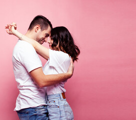 young cheerful caucasian couple together having fun on pink background, guy ang girl modern relationship, lifestyle people concept
