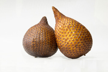 tropical fruit salak (Salacca zalacca) with brown outer skin resembling snake skin, isolated on a...