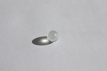 Clear glass bead reflect light on the white background.