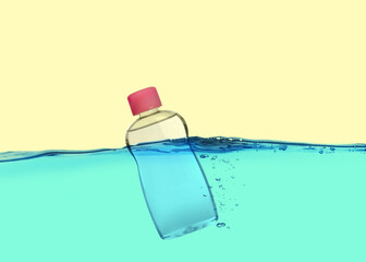 Bottle of baby oil floating in water against beige background