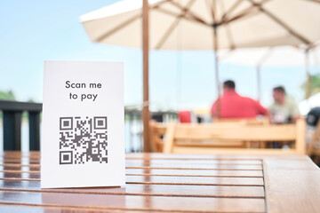 QR code for contactless, cashless payment, placed on the table of a restaurant.