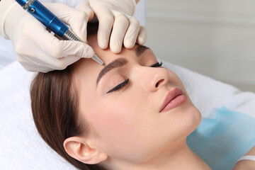 Young woman during procedure of permanent eyebrow makeup in beauty salon, closeup - obrazy, fototapety, plakaty