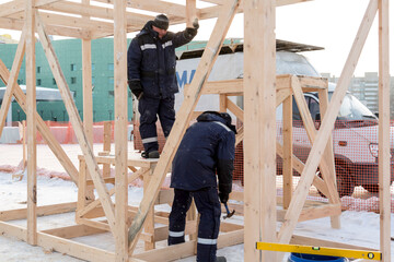 Fototapeta premium Worker in winter overalls with a hammer in his hand