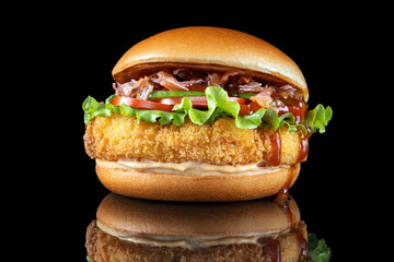 Bacon cheeseburger hamburger isolated on black. BBQ sauce and lettuce. Beautiful black mirror background.