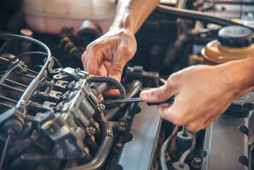 Close up Car Mechanic man hands repairing car auto repair shop. Man hands fixing machinery vehicle mechanical service. open vehicle hood checking up auto mobile. Vehicle Car maintenance engineer.