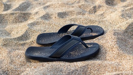 slippers buried in the sand on the beach
