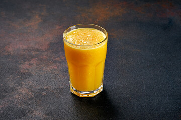 Orange juice in a glass on a black background