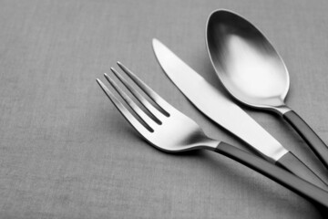 Set of shiny silver cutlery on grey table, closeup