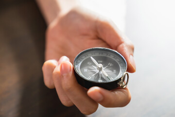 Close up of hand holding compass business navigate, passing through the crisis and growth in the...