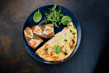 Breakfast omelet with sandwiches on a black background