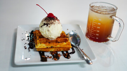 Chocolate Waffle topped with ice cream and cherries.
