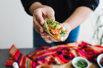 Mexican woman hands preparing tacos al pastor with sauce in Mexico city