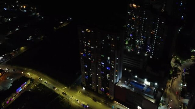 Gran ciudad nocturna, a lo lejos autos y edificios