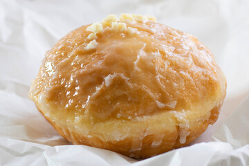 Traditional Polish Donut paczki are rich donuts that are deep fried and filled with fruit jam, custard or cream. Sweet and delicious snack, unhealthy food indulgent treat.