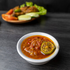 Grilled chicken with soy sauce and garnish with cucumber, tomato, lettuce, and chili