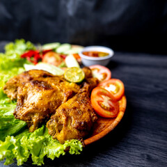 Grilled chicken with soy sauce and garnish with cucumber, tomato, lettuce, and chili