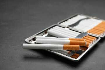 Stylish case with cigarettes on black table, closeup