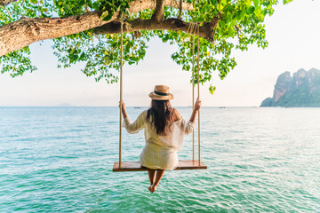 Traveler woman relaxing on swing above Andaman sea Railay beach Krabi, Leisure tourist travel Phuket Thailand summer holiday vacation trip, Beautiful destinations place Asia, Happy dream concept