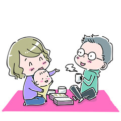 ピクニックシートを広げてお弁当を食べる家族